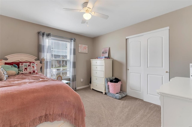 bedroom with a closet, light colored carpet, and a ceiling fan