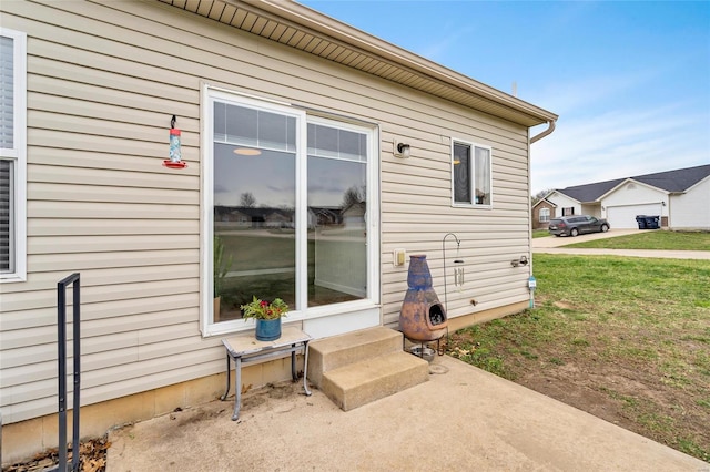 view of exterior entry with a yard