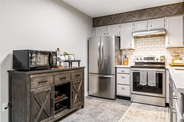 kitchen with tasteful backsplash, white cabinets, stainless steel appliances, light countertops, and under cabinet range hood