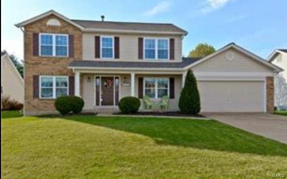 view of front of house with a garage, a front yard, and concrete driveway