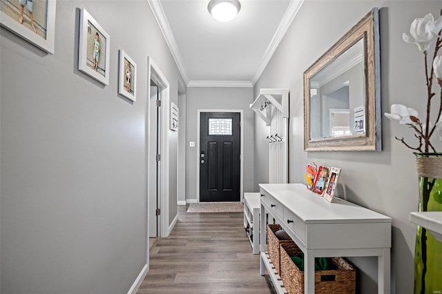 entryway with crown molding, baseboards, and wood finished floors