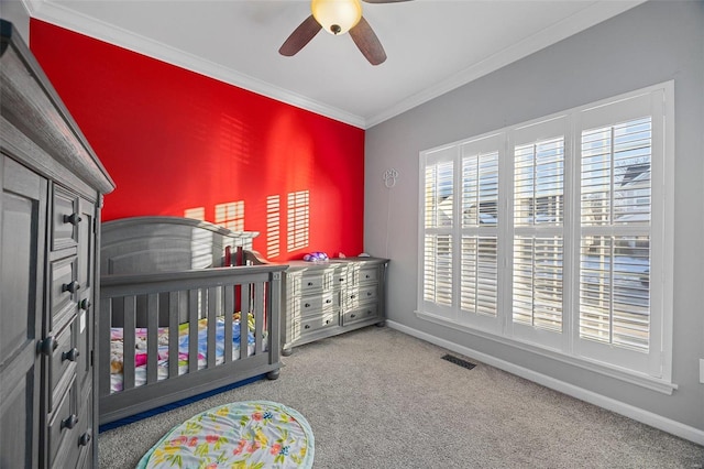 carpeted bedroom featuring ornamental molding, visible vents, baseboards, and a ceiling fan