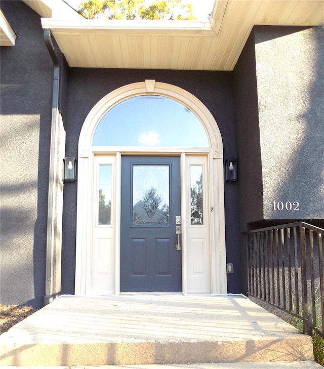 doorway to property featuring stucco siding