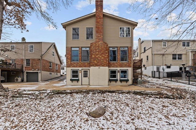 snow covered property with a garage