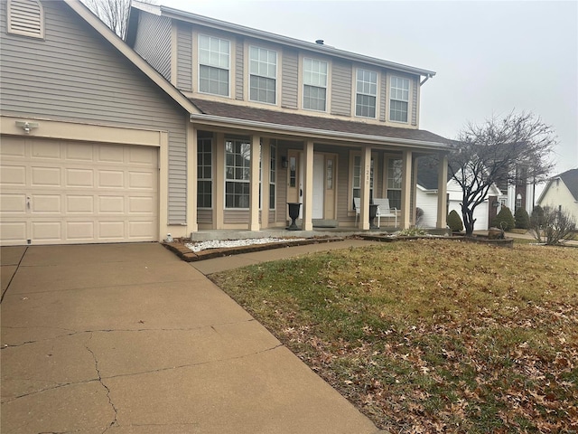 view of front facade featuring a front yard, a garage, and a porch