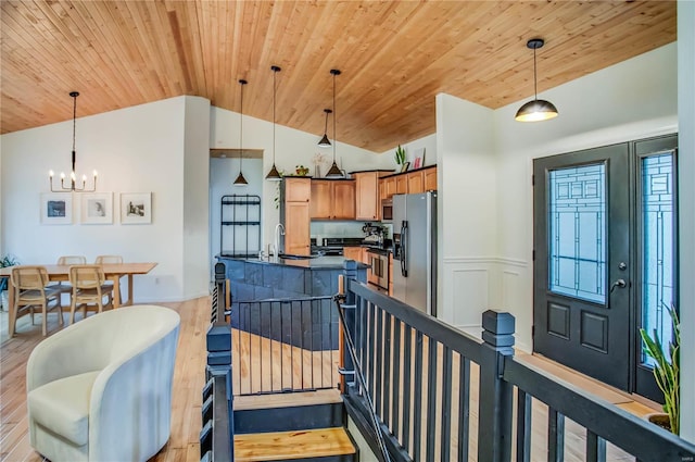 kitchen with appliances with stainless steel finishes, light hardwood / wood-style flooring, lofted ceiling, decorative light fixtures, and wood ceiling