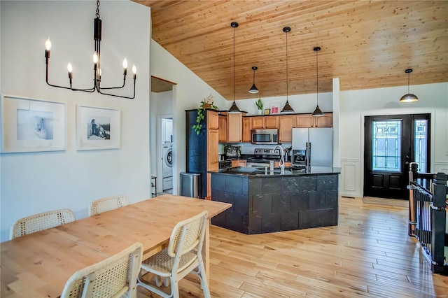 kitchen with decorative light fixtures, light hardwood / wood-style floors, stainless steel appliances, wooden ceiling, and a kitchen island with sink