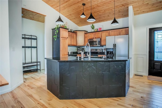 kitchen featuring light wood-type flooring, stainless steel appliances, wooden ceiling, hanging light fixtures, and an island with sink