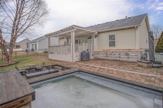 rear view of property with a pergola, a patio area, and a fenced in pool