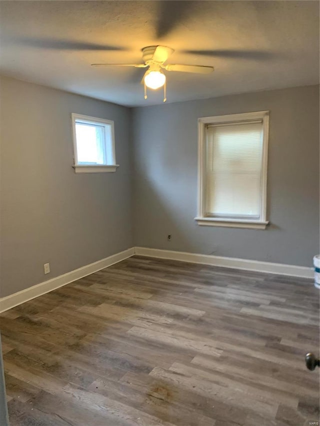 unfurnished room featuring dark wood-type flooring and ceiling fan