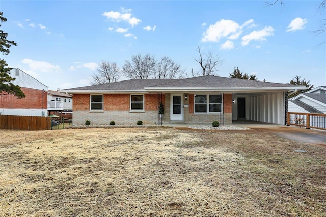 ranch-style home with brick siding, cooling unit, a shingled roof, fence, and an attached carport