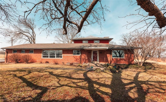 view of front of property featuring brick siding and a front yard