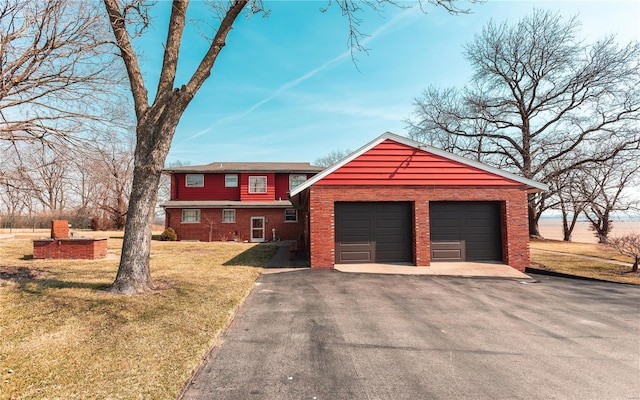 view of front of house featuring driveway, brick siding, an attached garage, and a front lawn