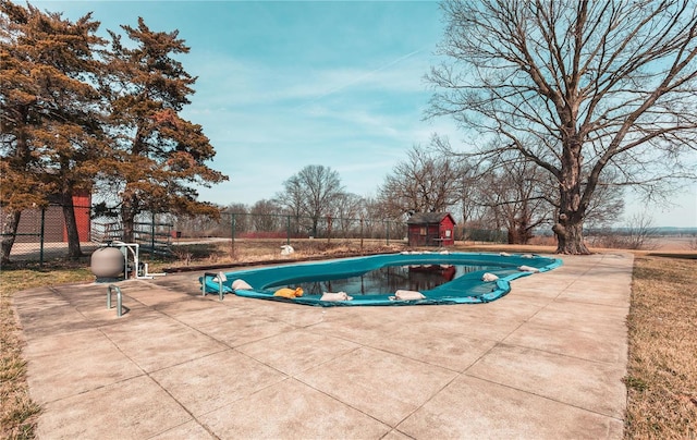 view of swimming pool featuring a patio area, fence, and a fenced in pool