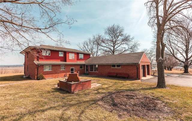 back of house with a lawn and brick siding