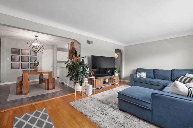 living room with a notable chandelier and wood-type flooring