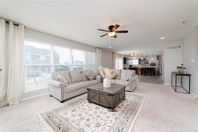 carpeted living room with ceiling fan