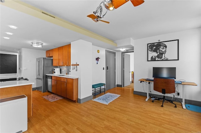 kitchen with light hardwood / wood-style flooring, sink, tasteful backsplash, ceiling fan, and appliances with stainless steel finishes