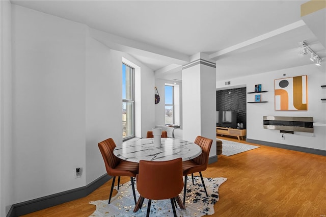 dining room featuring hardwood / wood-style floors and ornate columns