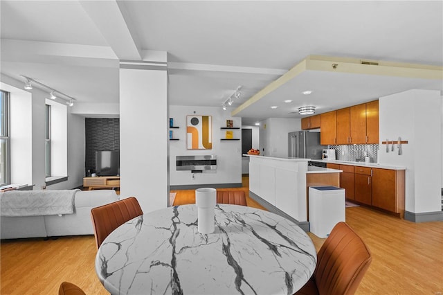 dining space featuring light wood-type flooring and sink