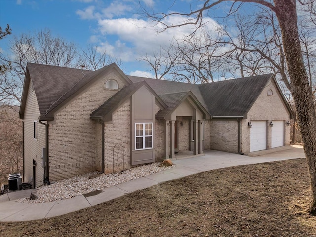 view of front of home with a garage, driveway, brick siding, and roof with shingles