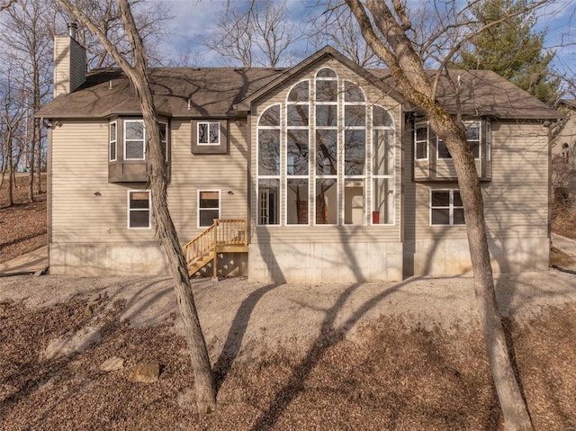 rear view of house featuring a chimney