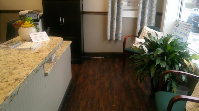 kitchen featuring black refrigerator, light stone countertops, and dark hardwood / wood-style floors