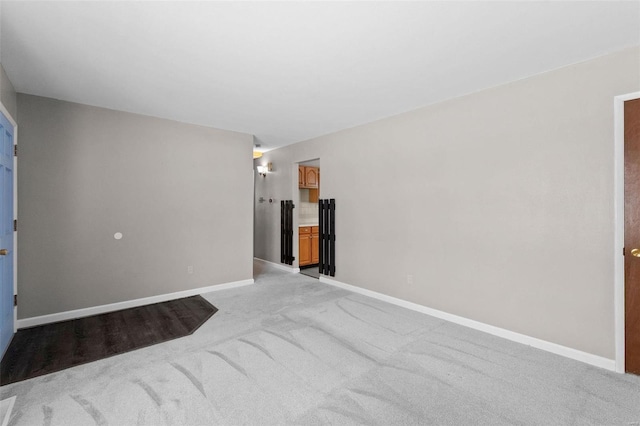 empty room with baseboards and light colored carpet