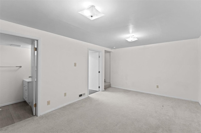 unfurnished bedroom featuring baseboards, visible vents, and light colored carpet