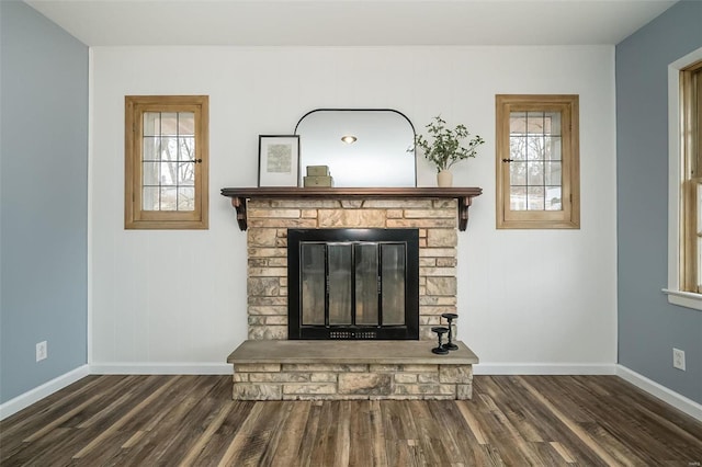 interior details with baseboards, wood finished floors, and a stone fireplace