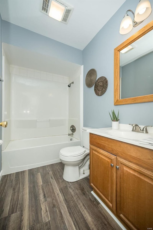 full bathroom with shower / washtub combination, visible vents, toilet, vanity, and wood finished floors