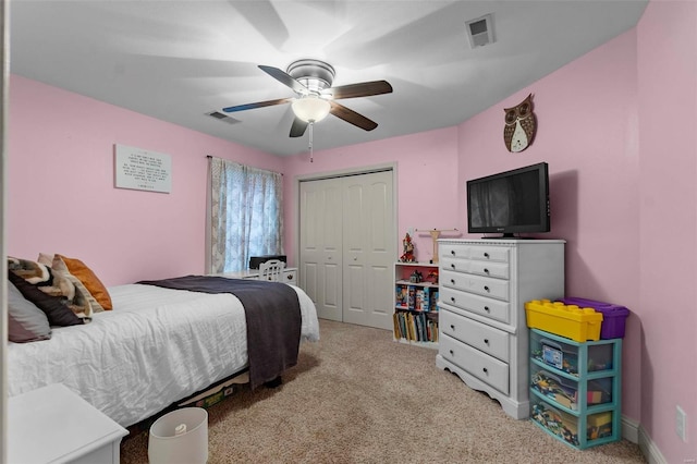 bedroom featuring ceiling fan, light carpet, and a closet