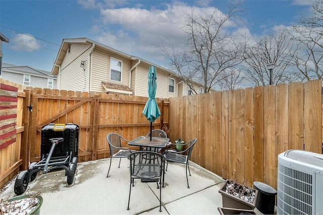 view of patio with outdoor dining space, cooling unit, and fence