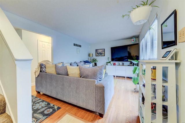 living area with wood finished floors and visible vents