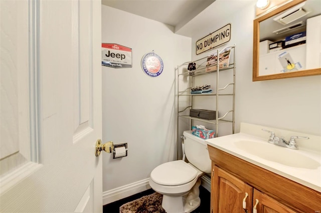 bathroom featuring toilet, baseboards, and vanity