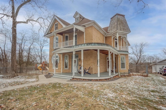 view of front of house featuring a playground, a balcony, and covered porch