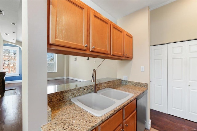 kitchen featuring dishwasher, light stone counters, a sink, and dark wood-style floors