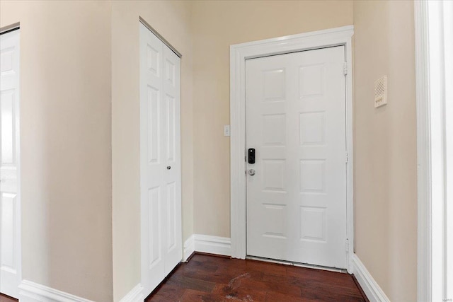 entryway with dark wood-style floors and baseboards