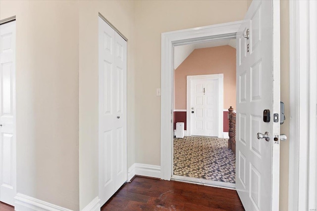 hall featuring baseboards and dark wood finished floors