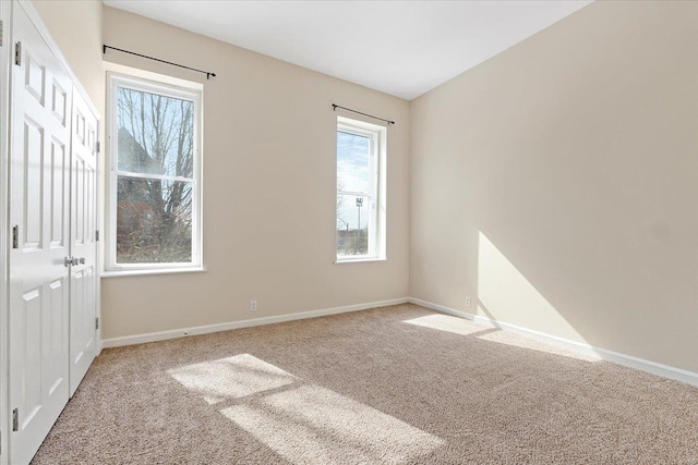 empty room with light carpet and baseboards