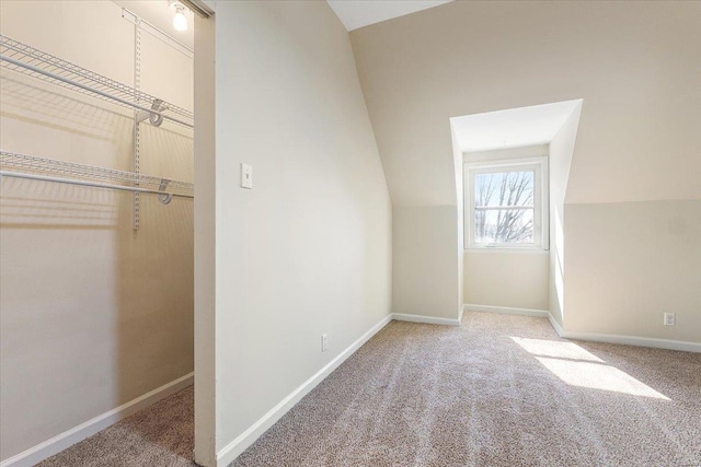 unfurnished bedroom with carpet floors, vaulted ceiling, and baseboards