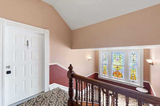 foyer entrance featuring lofted ceiling and baseboards