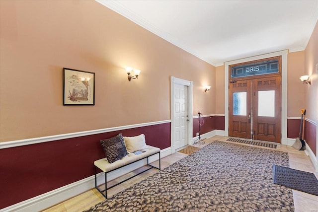 entryway featuring light tile patterned flooring, crown molding, and baseboards