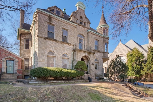 view of front of house with a balcony and stone siding