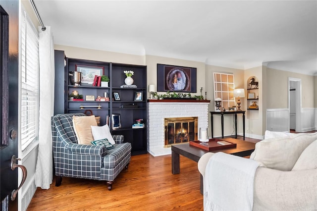 living room with hardwood / wood-style flooring and a brick fireplace