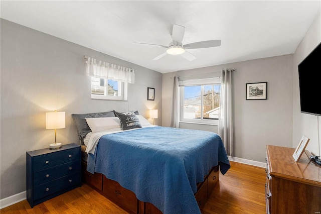 bedroom featuring wood finished floors, baseboards, and ceiling fan