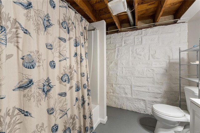 full bath with toilet, concrete floors, and shower / tub combo with curtain