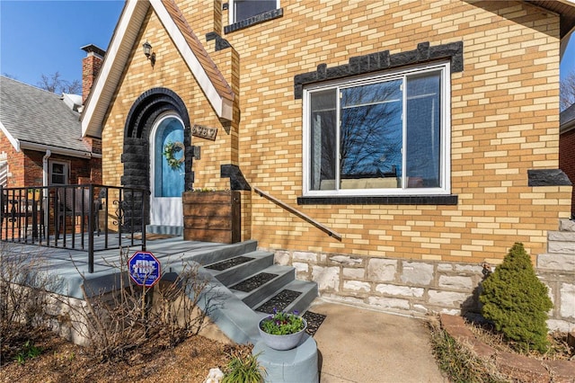 view of exterior entry featuring brick siding