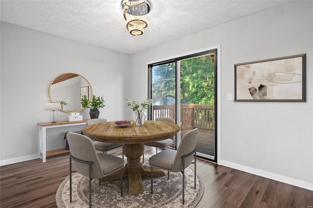 dining room with dark hardwood / wood-style floors and a textured ceiling
