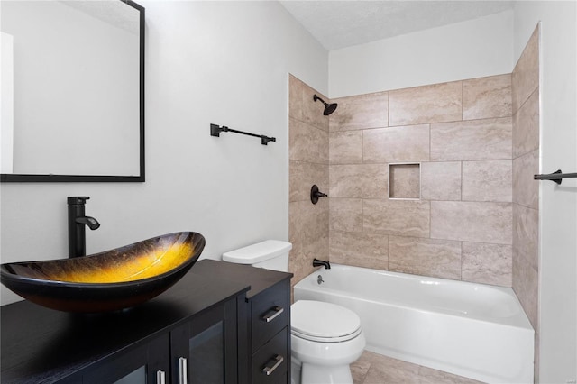 full bathroom featuring tiled shower / bath, tile patterned flooring, vanity, toilet, and a textured ceiling